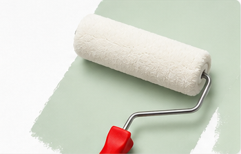Paint roller on a pale green painted surface